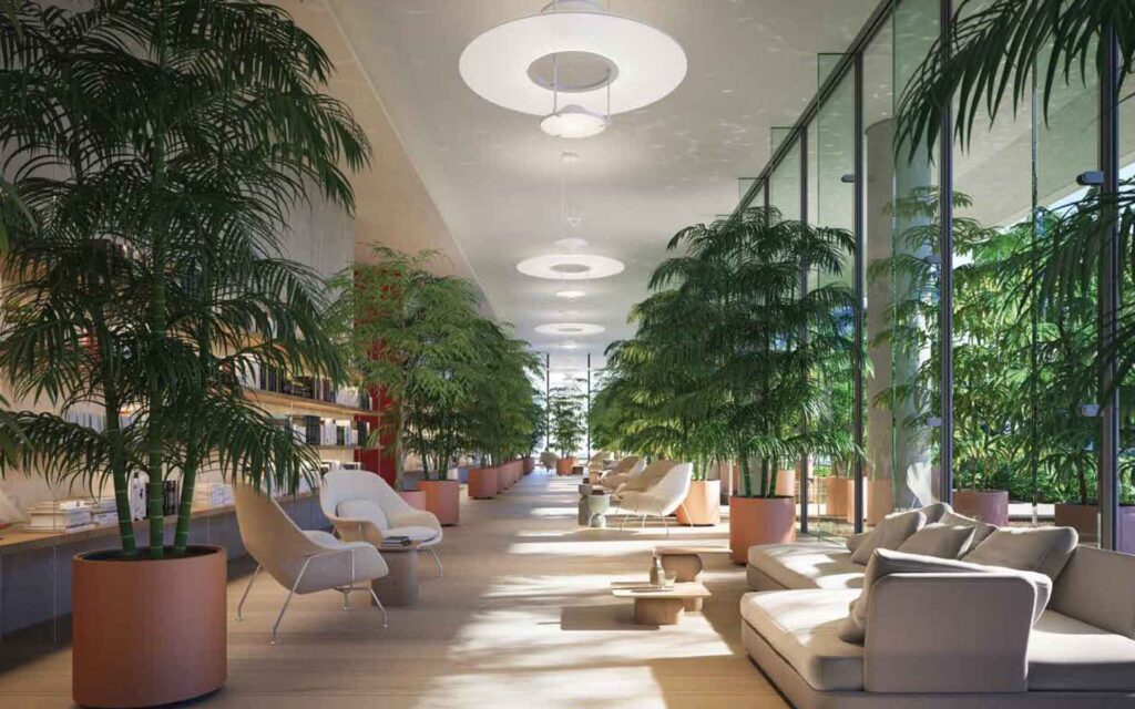 a view into a lobby at 87 park with lush green tropical trees and seating surrounded by large windows