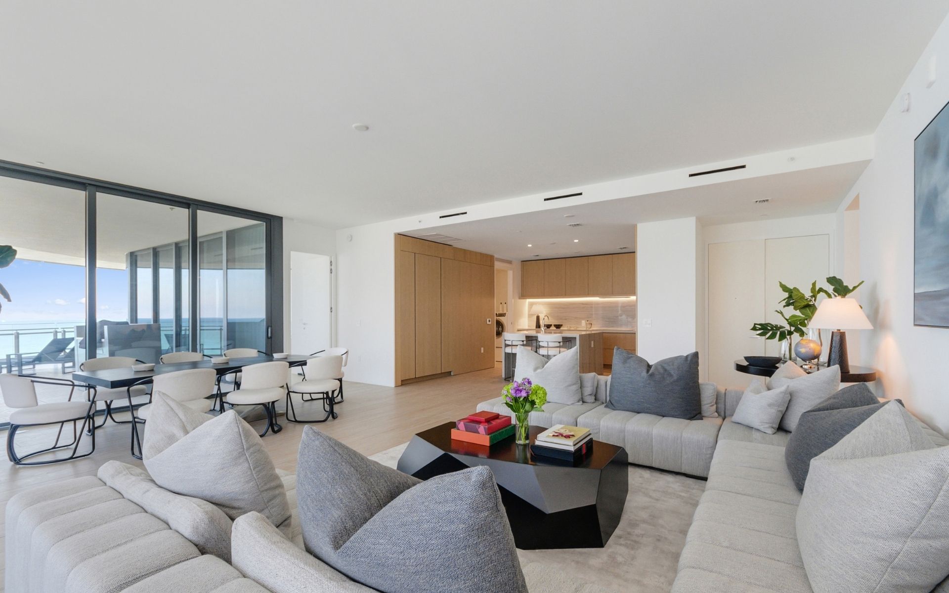 sample living room inside 87 Park Residences featuring modern furniture and a deck overlooking Miami beach